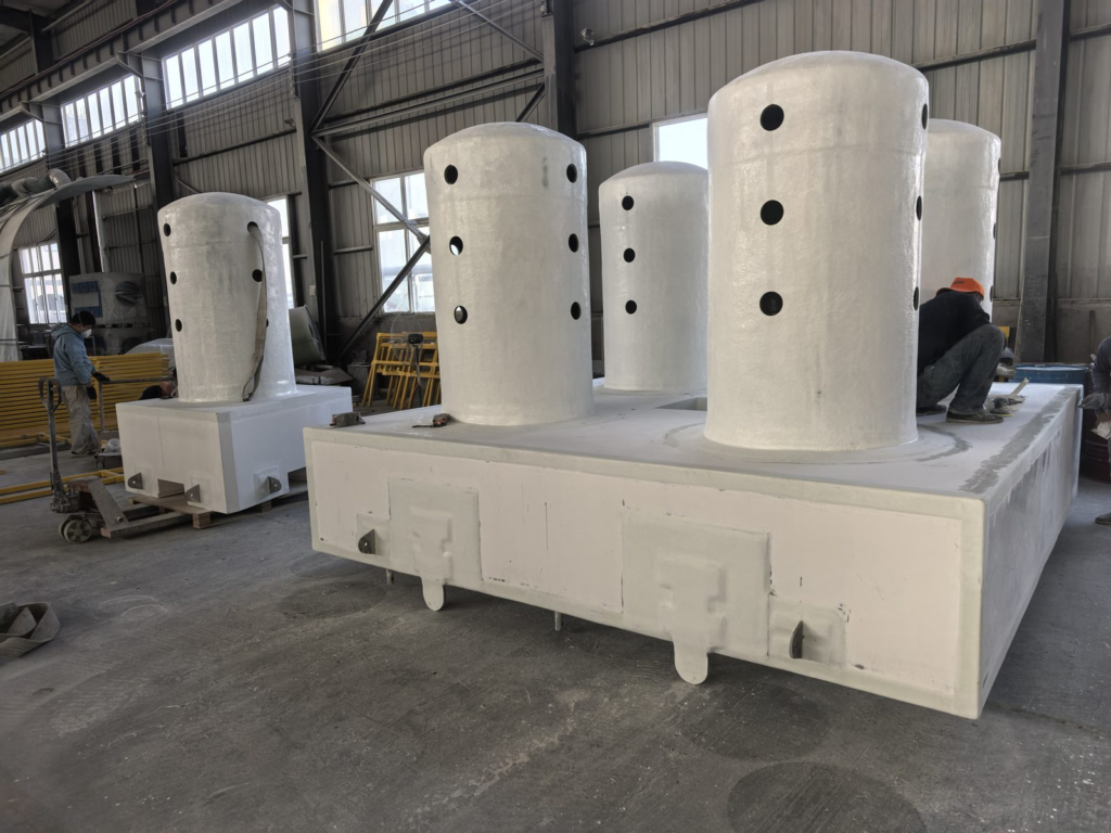 FRP pump barge hull turned over in the fabrication shop, showing four ported ballast columns