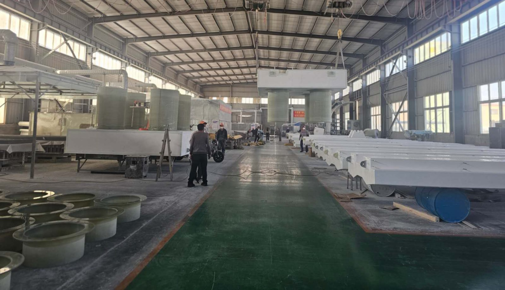 Overhead crane lifting an FRP pump barge with ballast columns beside rows of floating walkway sections
